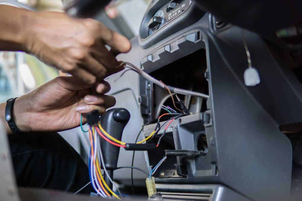 An electrician changing a car’s stereo and navigation system