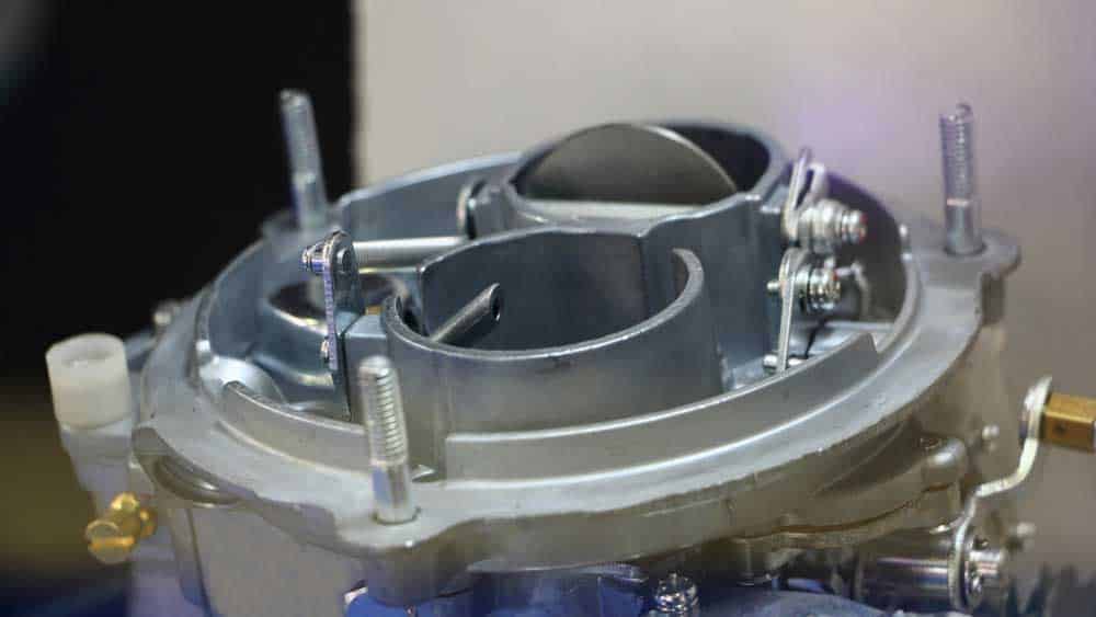 A dual-chamber car carburetor with a choke (the open flap)