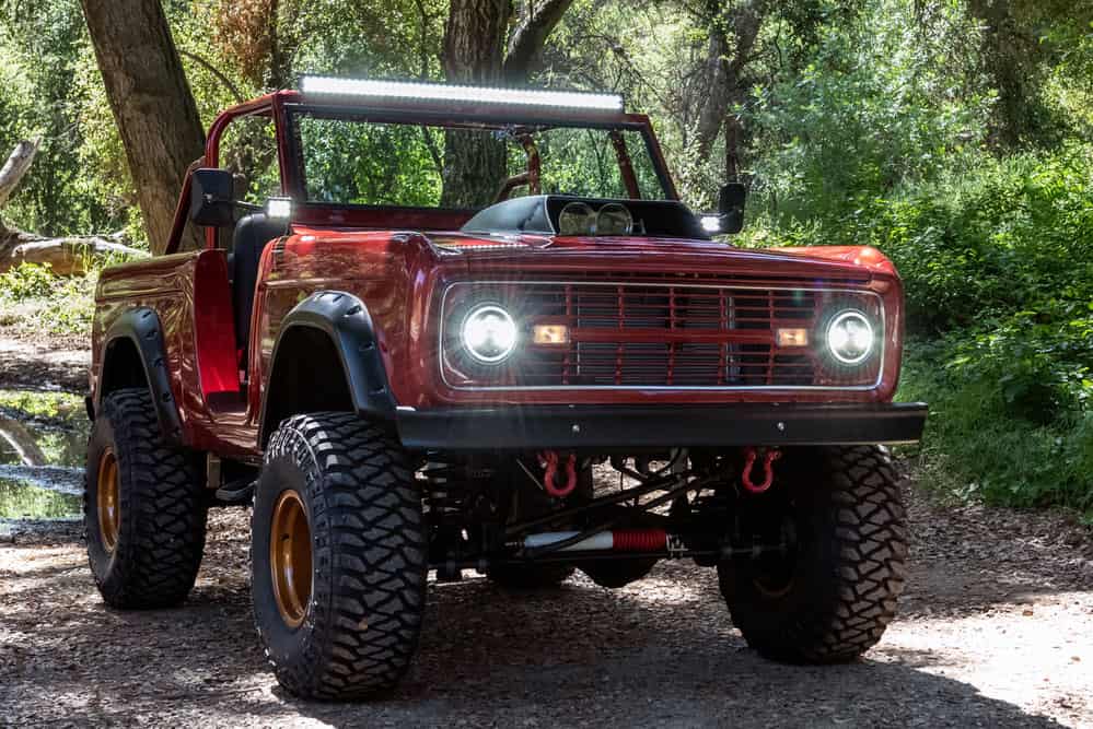 A convertible vintage truck with an LED light bar mounted at the top for offroad driving