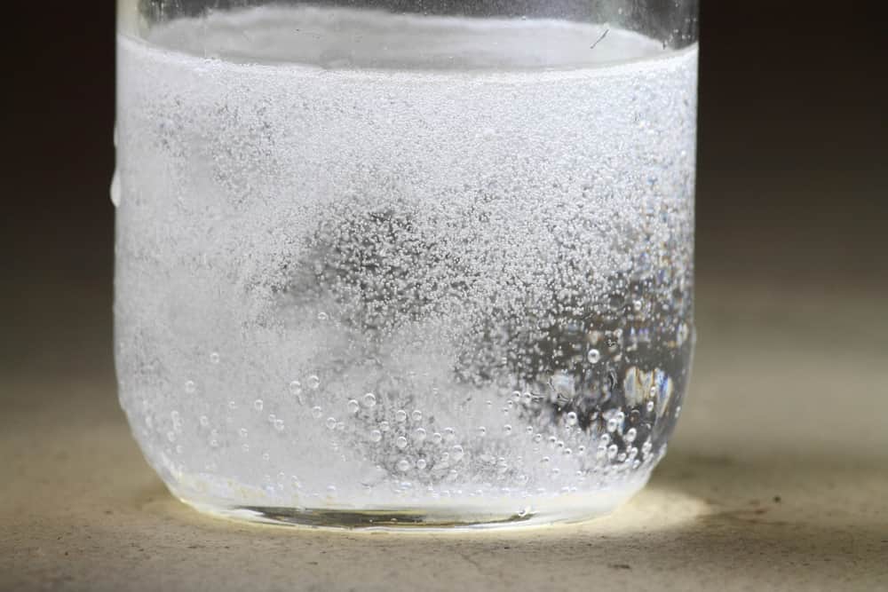 A reaction between baking soda and vinegar in a glass jar