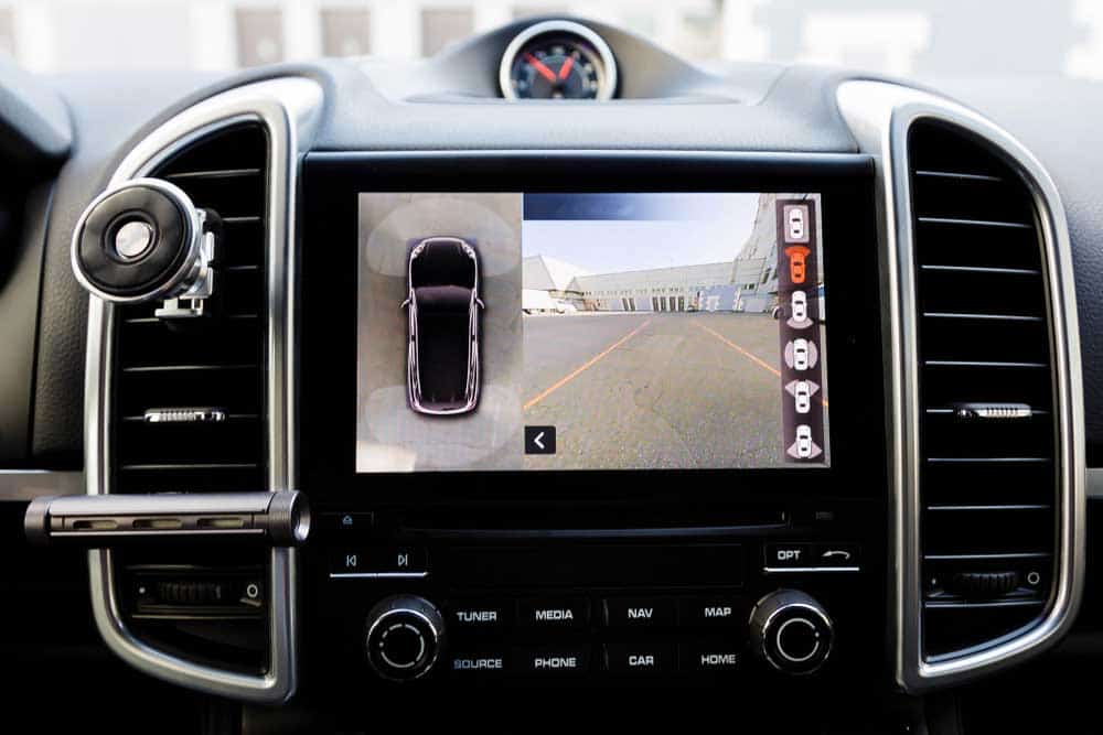 A luxury vehicle with a double-din head unit displaying images from the 360° cameras
