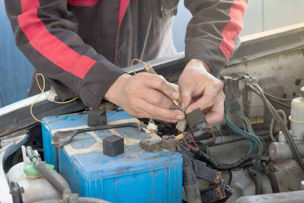 A mechanic testing a vehicle’s relay circuit
