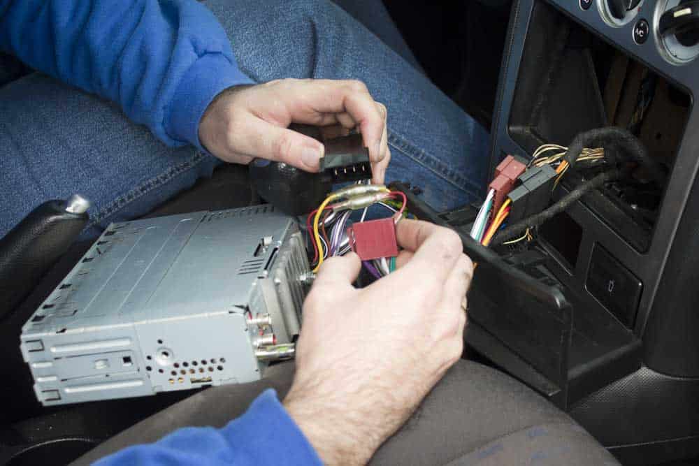 The car electrician connects the radio to the car. 