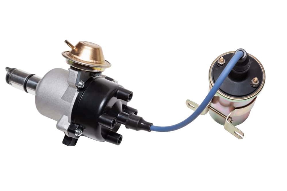 An ignition coil and distributor setup are connected using a high-voltage wire