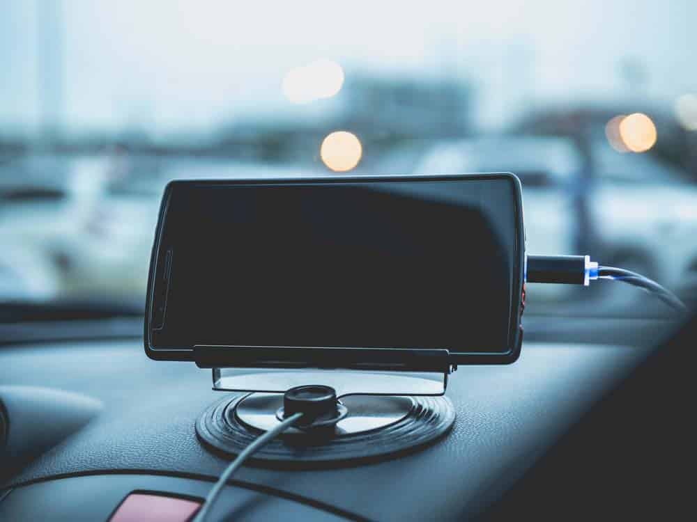A mobile phone charging while plugged into a dashboard console