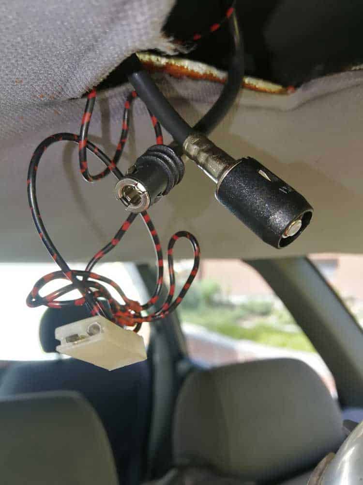 Car antenna connectors and wires hanging from the roof during installation